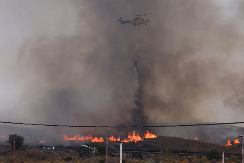 Un elicopter de stingere a incendiilor aruncă apă în mijlocul incendiilor forestiere devastatoare care afectează provincia Almería, în localitatea Los Gallardos, Almería, Spania, 10 iulie 2026. REUTERS